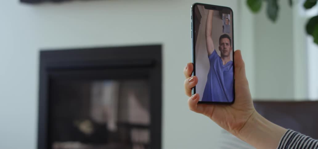 Two people stretch while talking on video phone
