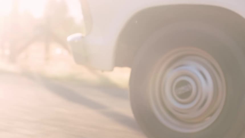 Close up of the tire of a white truck driving on a rural road at morning