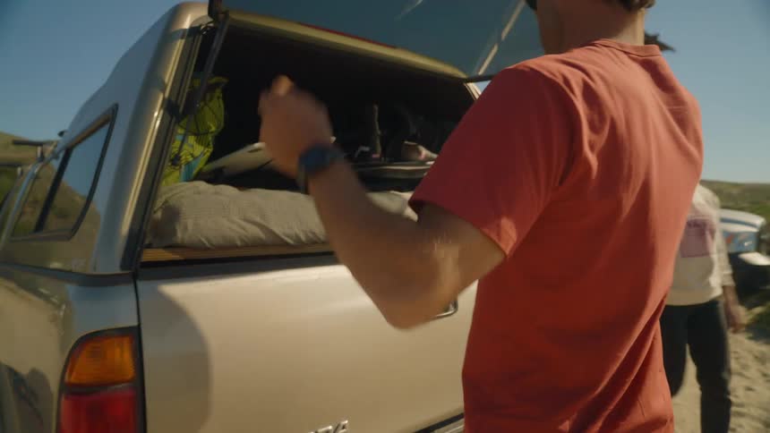 Man and woman are parked at the beach and going surfing