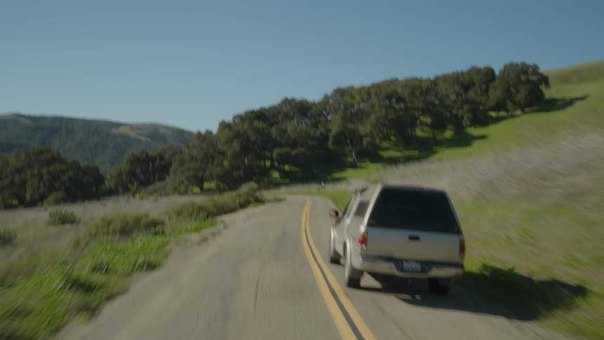 A pickup truck drives down an empty rural road