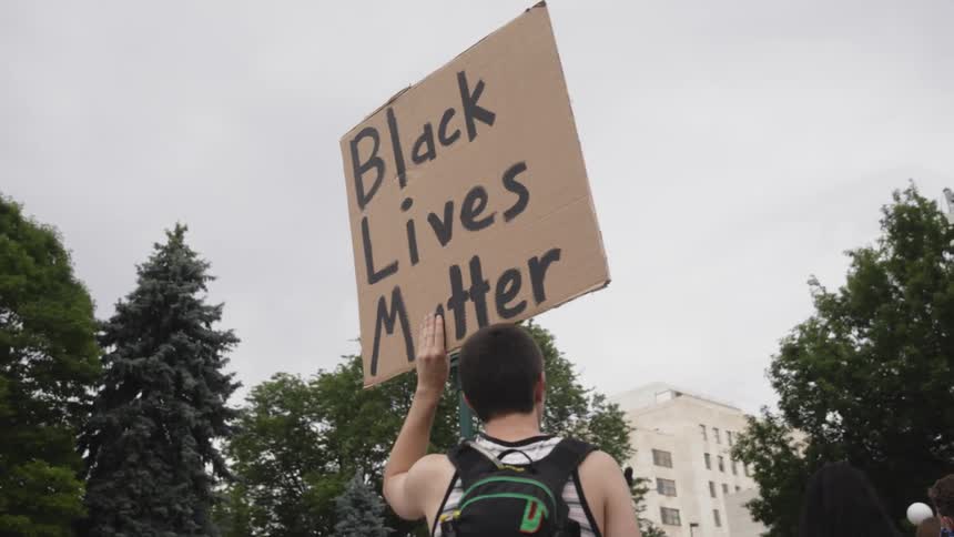A crowd is protesting and holding signs outdoors