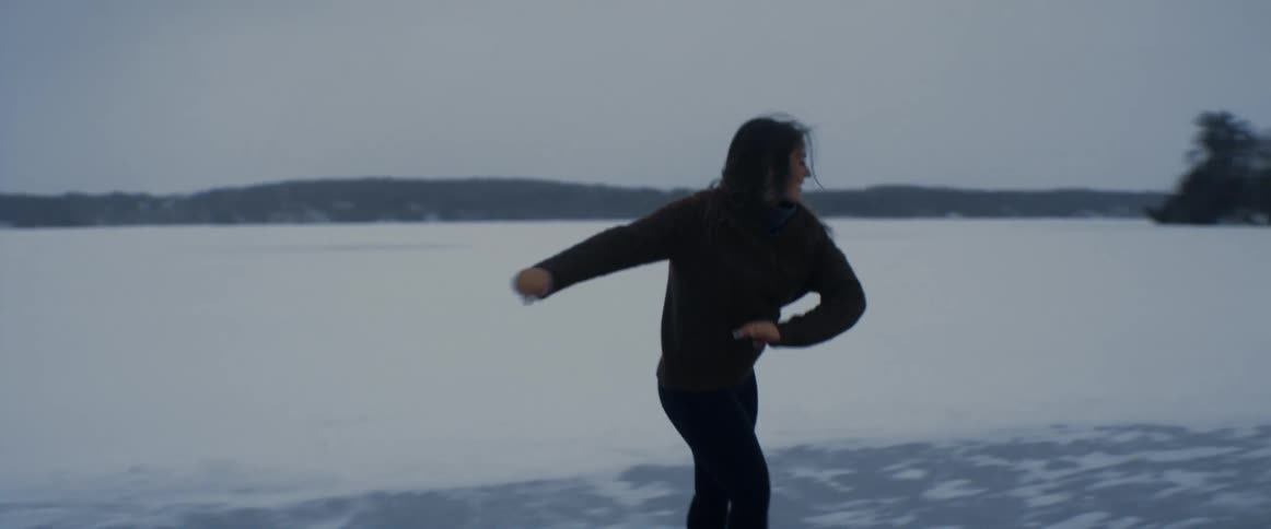 A woman is ice skating on the frozen lake