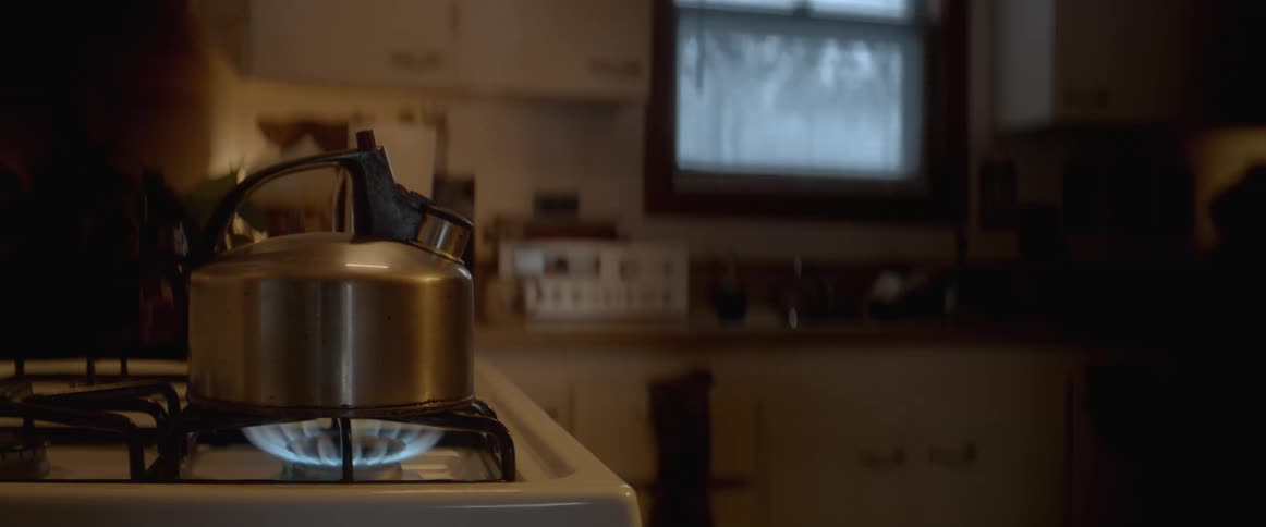 A kettle steaming over an open flame on a stove