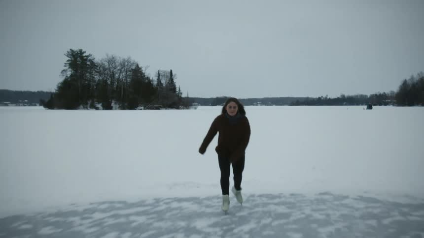 A woman ice skates on a frozen lake