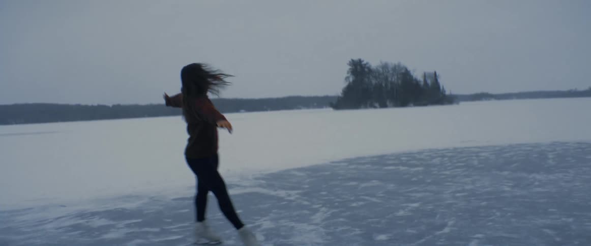 A woman is figure skating in the winter