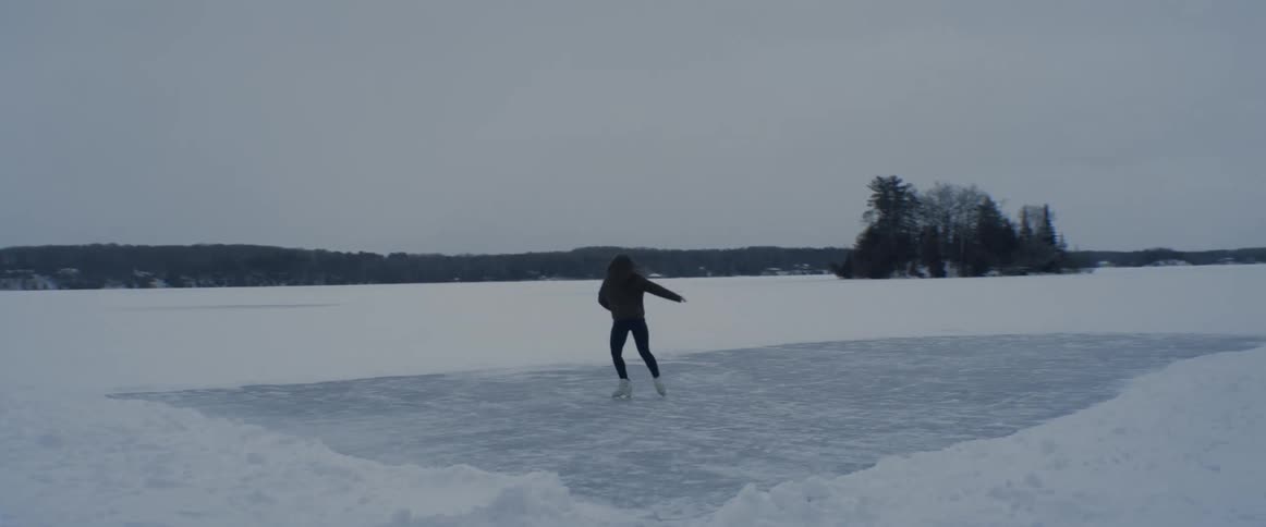 A woman is figure skating on the ice