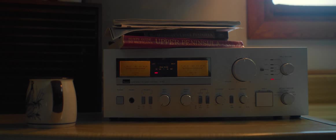 A vintage stereo beside a mug in a home