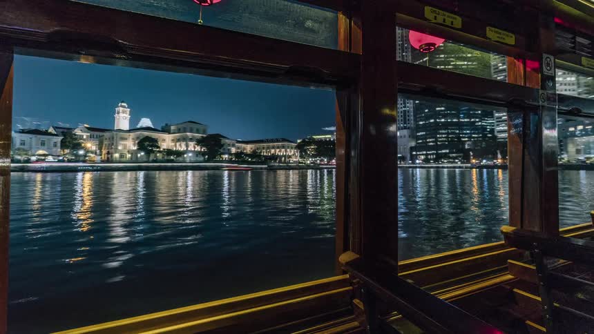 A ferry travels through the city water at night