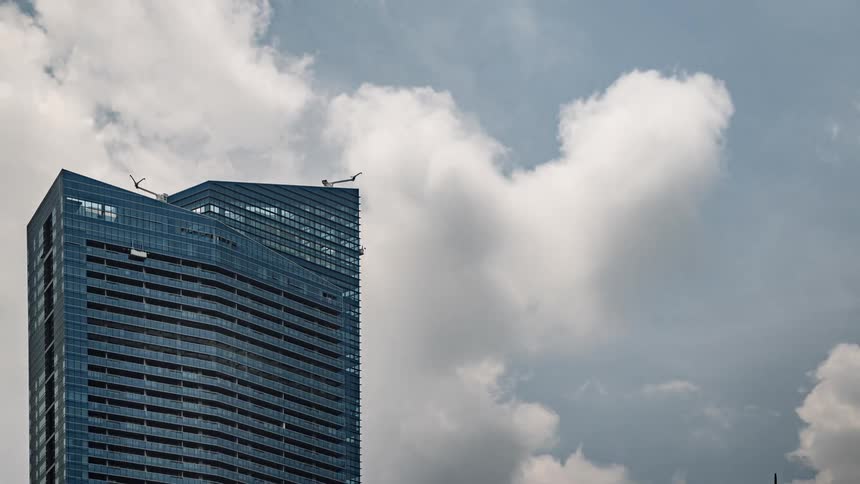Construction cranes move on top of skyscraper under construction