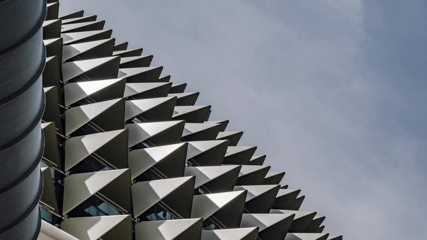 Clouds pass over building with triangular awnings over each window