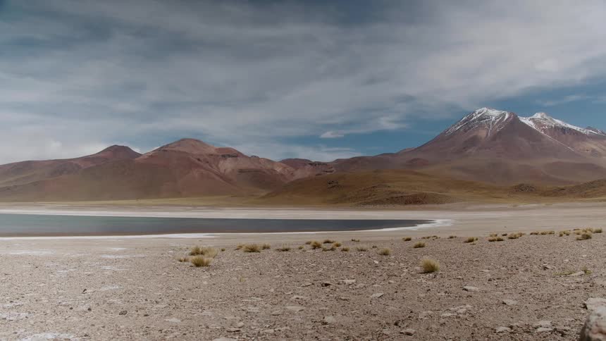 A landscape view with water in front of a mountain range