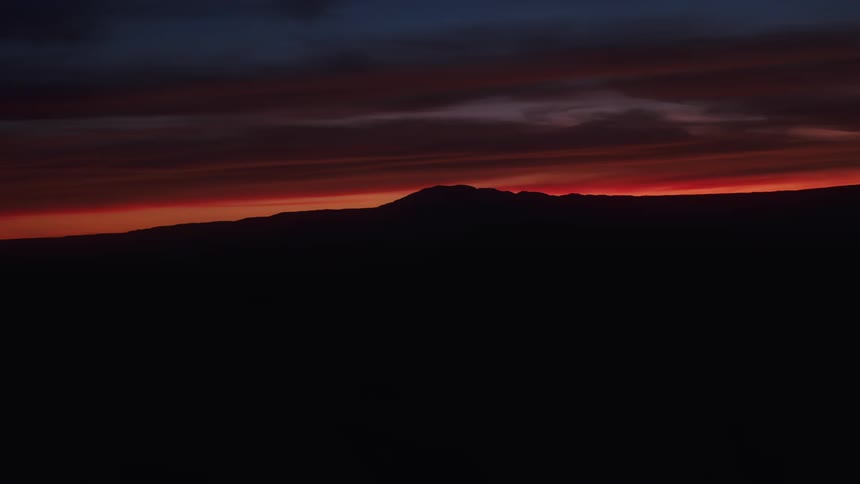 View of hills silhouetted against the sunrise