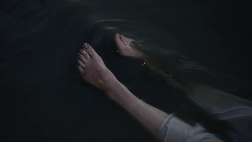 The lake water splashes over the bare feet and legs