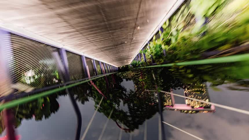 A pedestrian bridge runs over a river near downtown