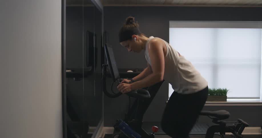 A woman at home exercises on a stationary bike