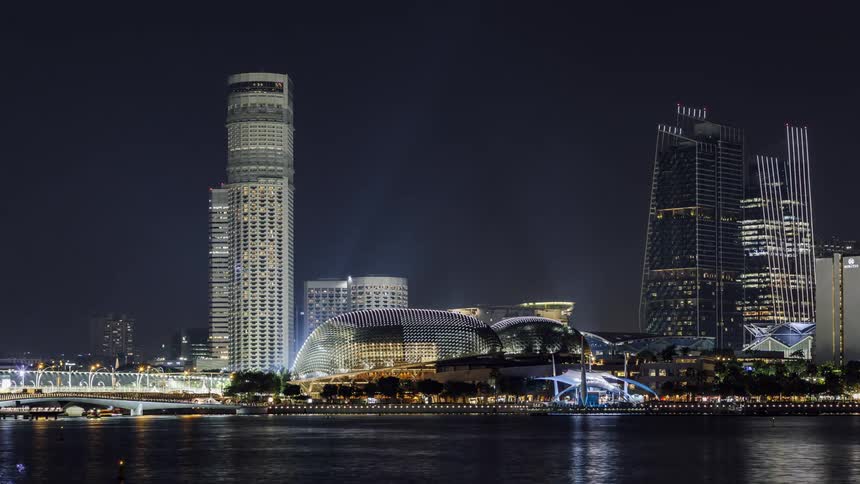 A time lapse of cars driving and lights flashing in a city on the water