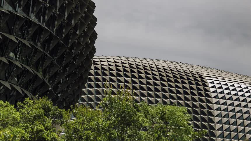 Wind blowing through shrubs in front of a large structure