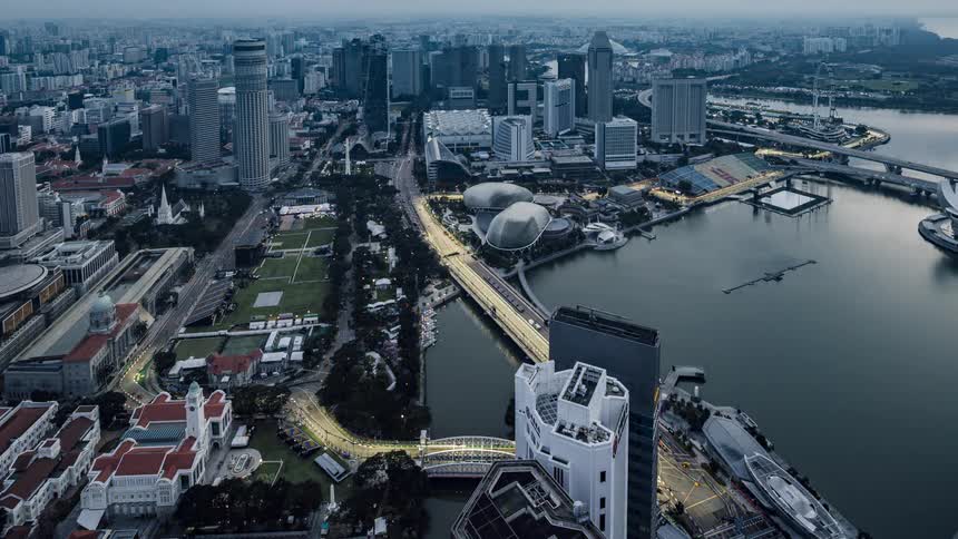 Aerial view of illuminated skyscrapers high rise buildings and bridges next to sea
