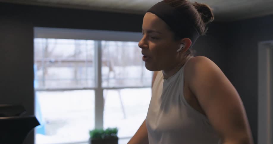 Woman wearing sports clothes stretches at home before exercising
