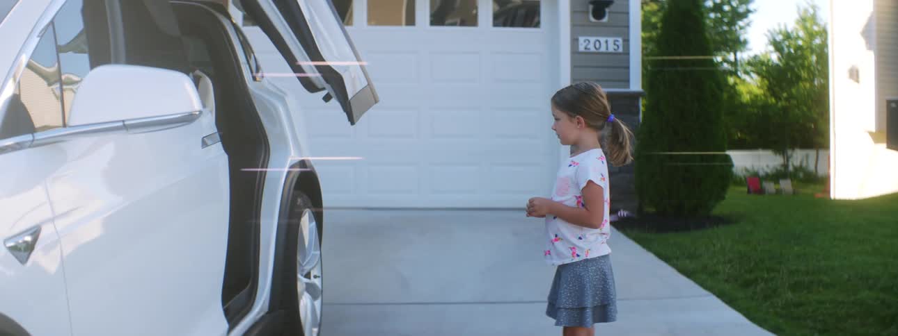 A young girl climbs into the back of a vehicle after the doors automatically slide open