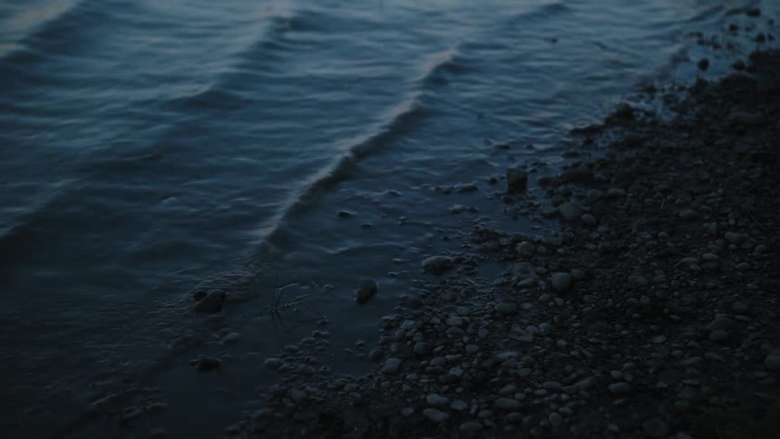 Small waves break against the pebble beach