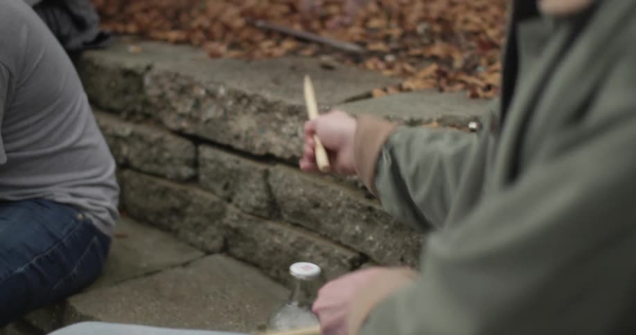 Street performer using drumsticks on blocks and a bottle