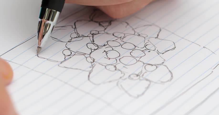 A man sketches a pattern on a notepad
