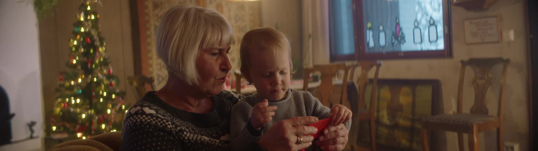 A grandmother shows a boy a toy