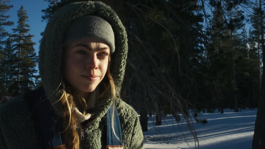 Woman hikes through snow covered conifer forest