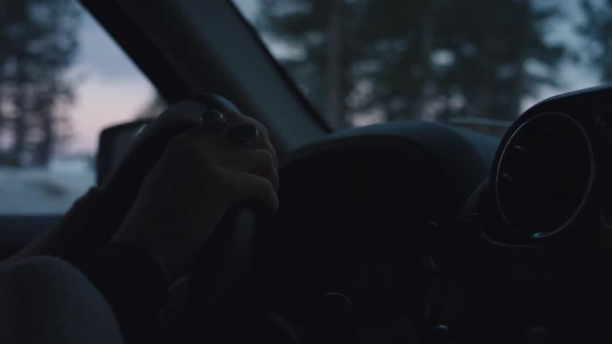 A woman driving a car on a cold winter morning