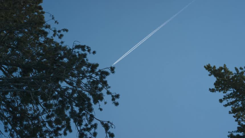 Airplane leaves behind white trails in the sky