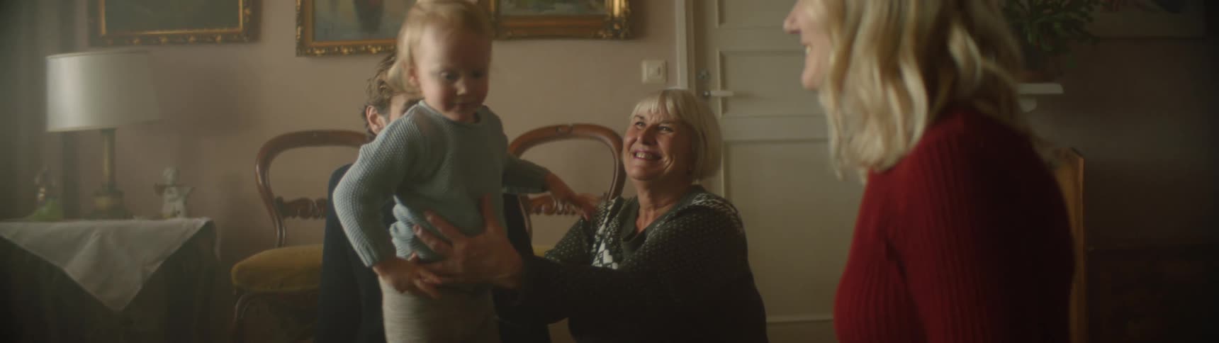 Family hug a child as he walks around