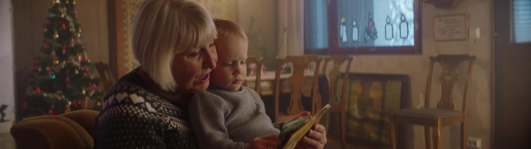 A grandmother reads a book to her grandson