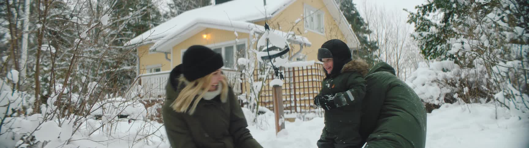 A family have a snowball fight outside