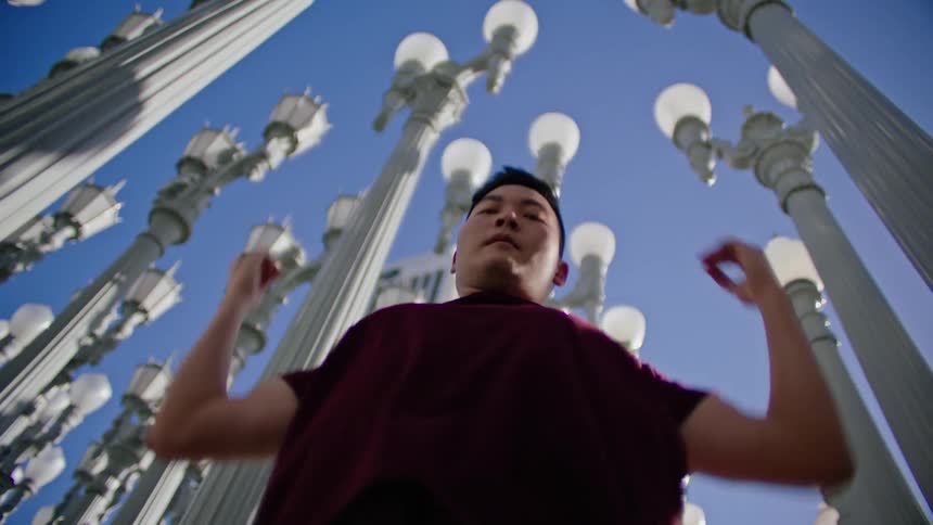 A teenage boy dances outside
