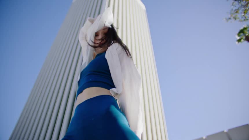 A woman is dancing in front of the building