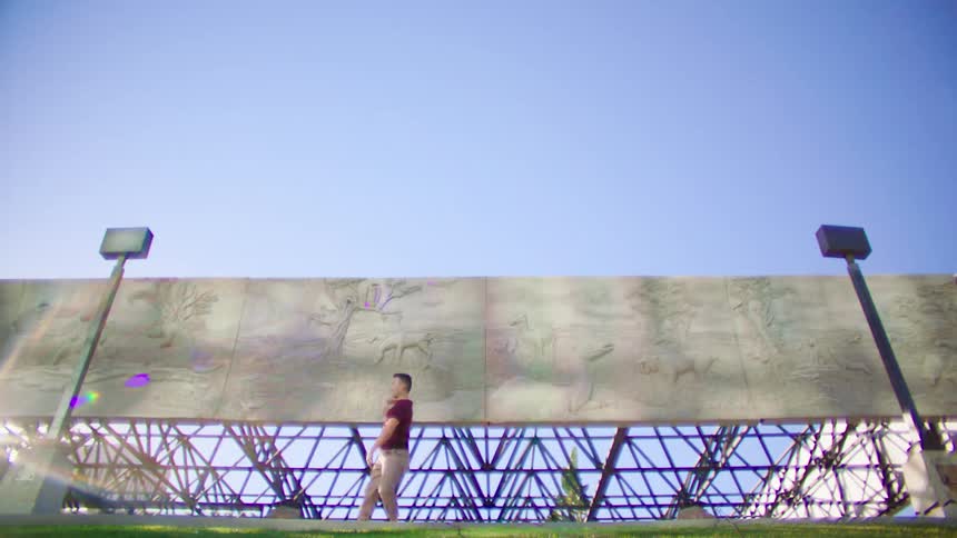 A man is dancing around under the billboard