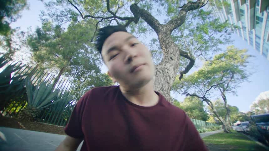 A man dances on the sidewalk near a tall condo
