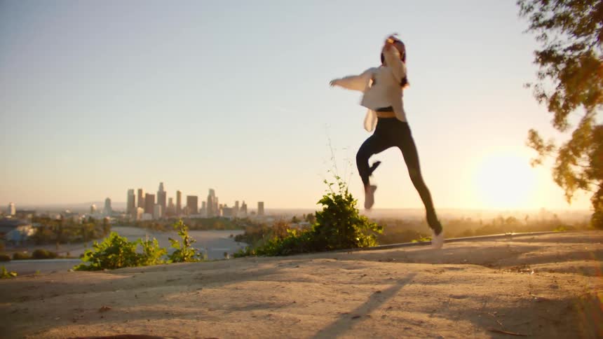A woman is dancing at sunrise