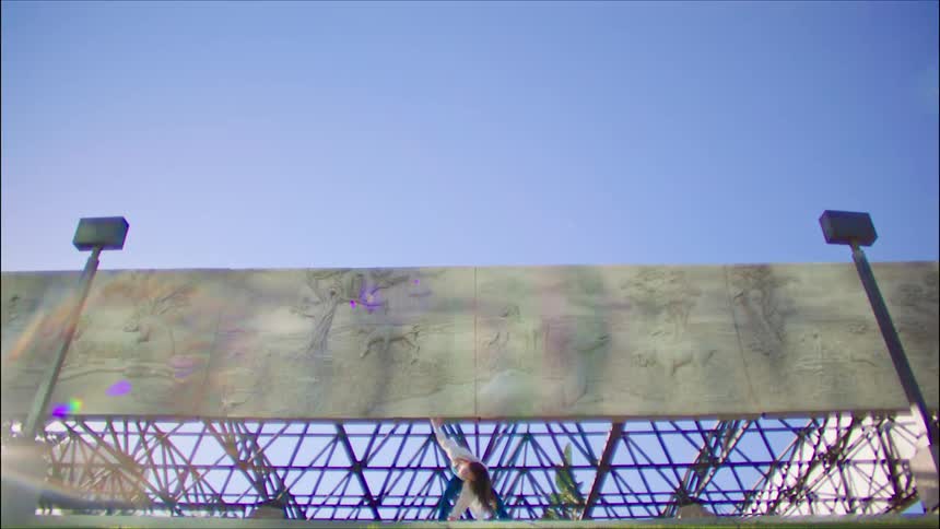 A woman is dancing up under the billboard