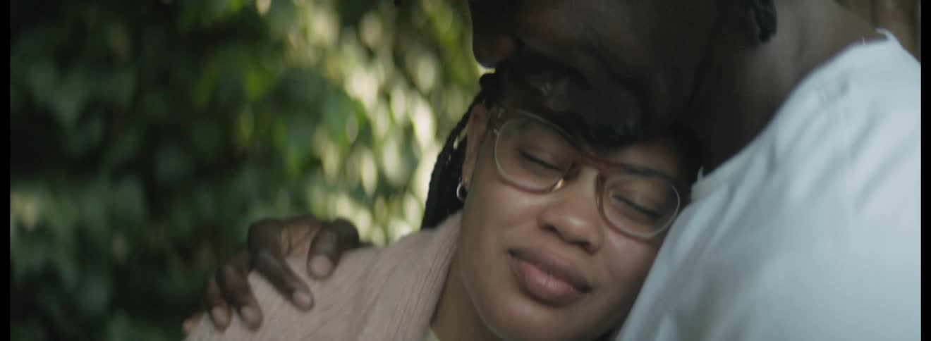 Young couple tenderly hugging near a tree in the garden at morning