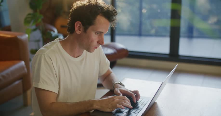 Male entrepreneur brainstorming while working on laptop at home