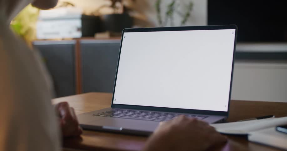 A man sits at a laptop with motion tracking markers on the screen