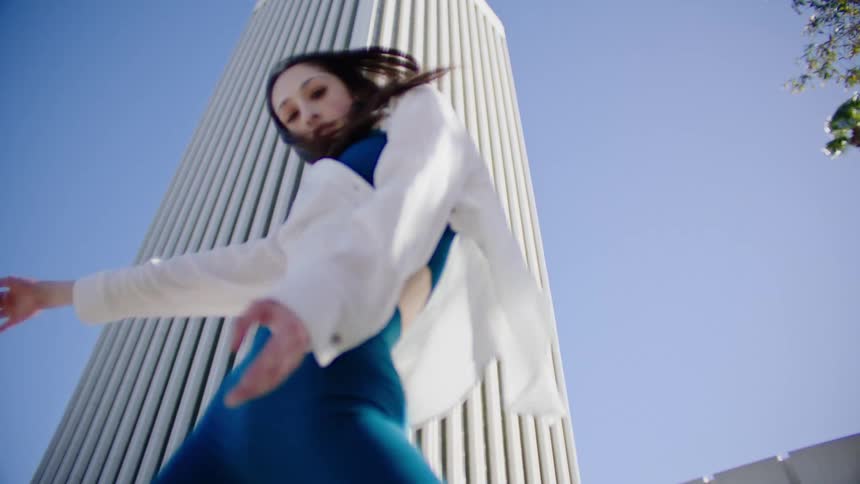 A woman is dancing on a windy day
