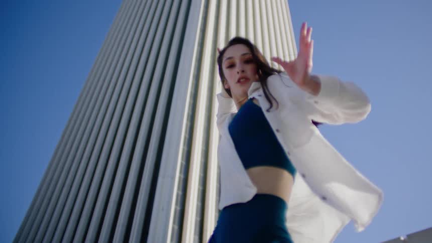 A woman is dancing outside on a windy day