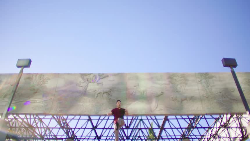 A man is dancing in front of the billboard