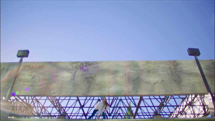 A woman is dancing under the billboard