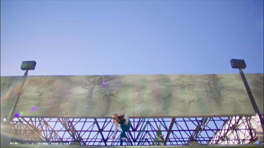 A woman does a modern dance in front of a billboard