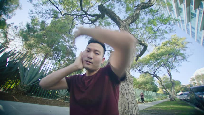 A man is dancing near the sidewalk