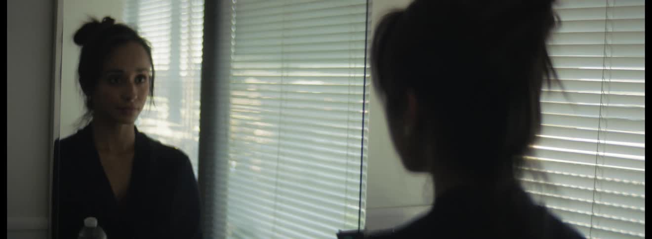 A woman checks herself in the window